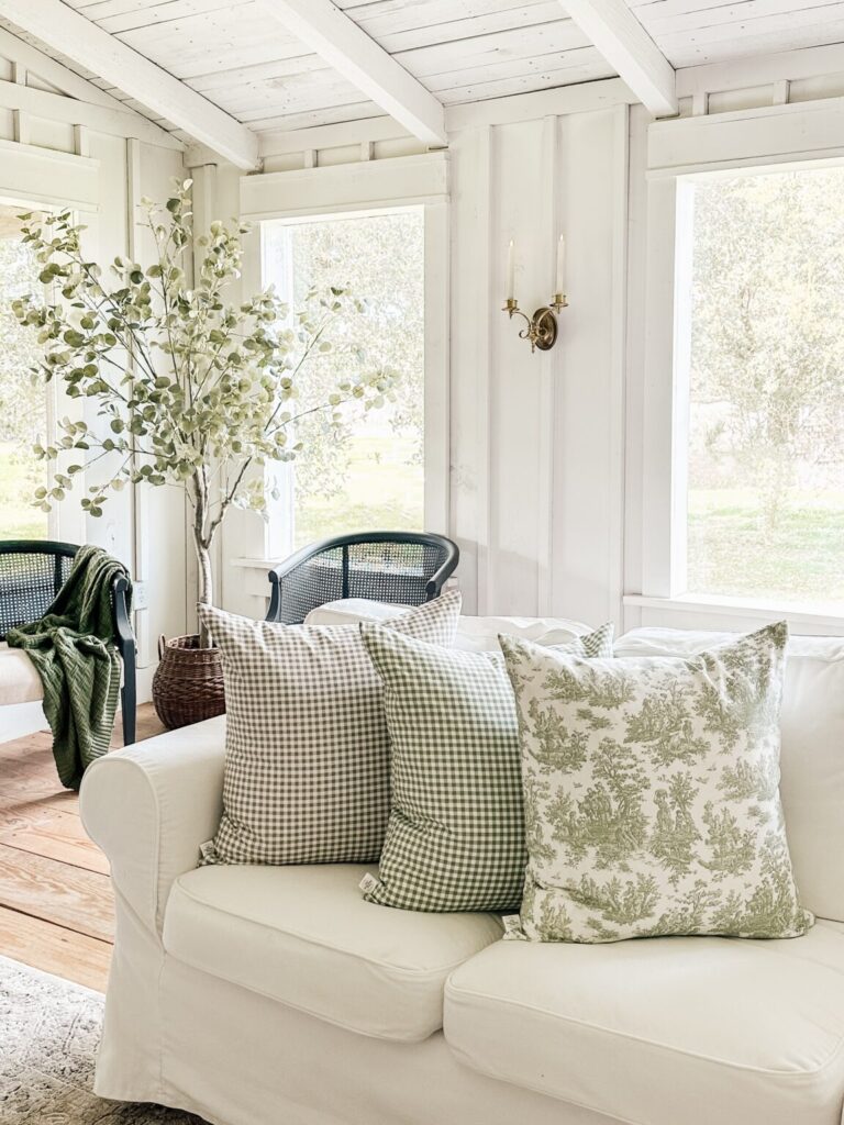 A photo of a sofa with three pillows covered in green, perfect for spring.
