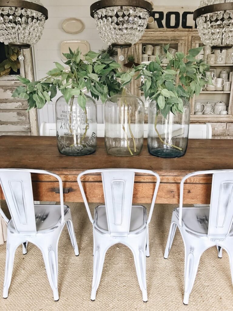 Large glass jugs and Spring branches on the table perfect for spring decoration.